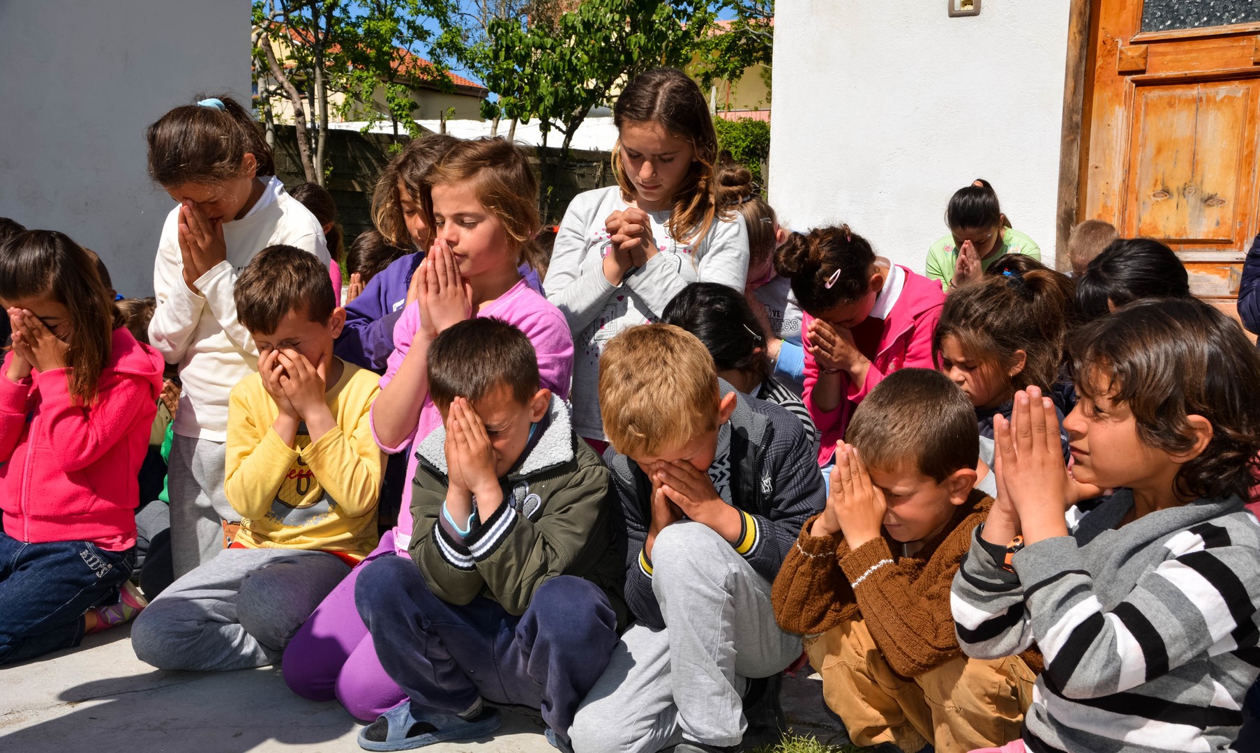Kinder beten im Freien bei einem Gottesdienst, Albanien